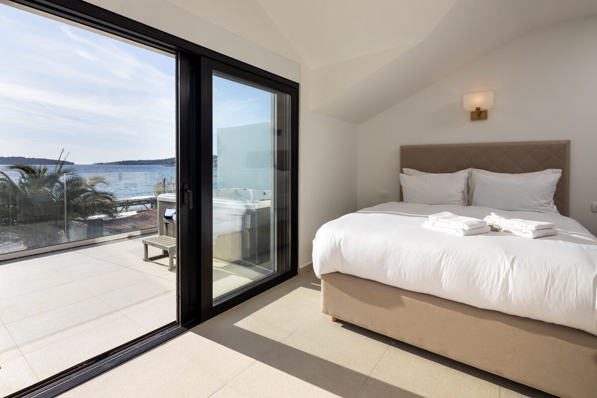 Master bedroom with king bed and sea view at The Beachhouse Rogoznica