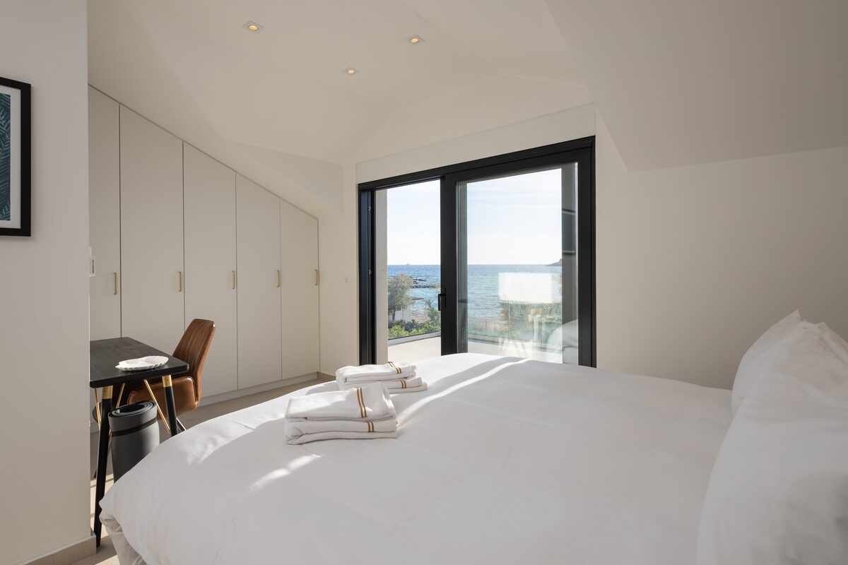 Master bedroom with king bed, quilted headboard and vaulted ceiling