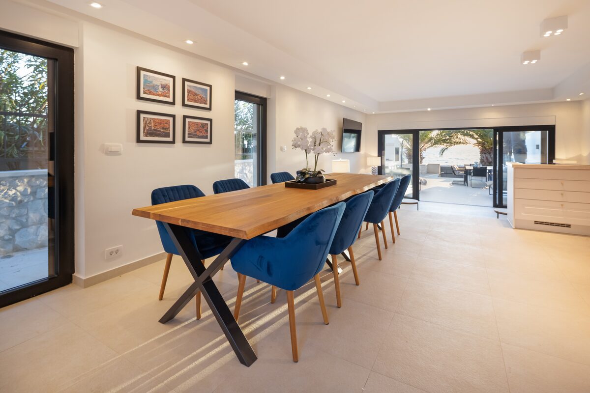 Open-plan dining area with oak table and royal-blue velvet chairs, The Beachhouse Rogoznica
