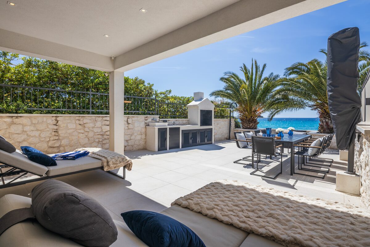 Terrace in afternoon light with parasols and dining table, The Beachhouse Rogoznica